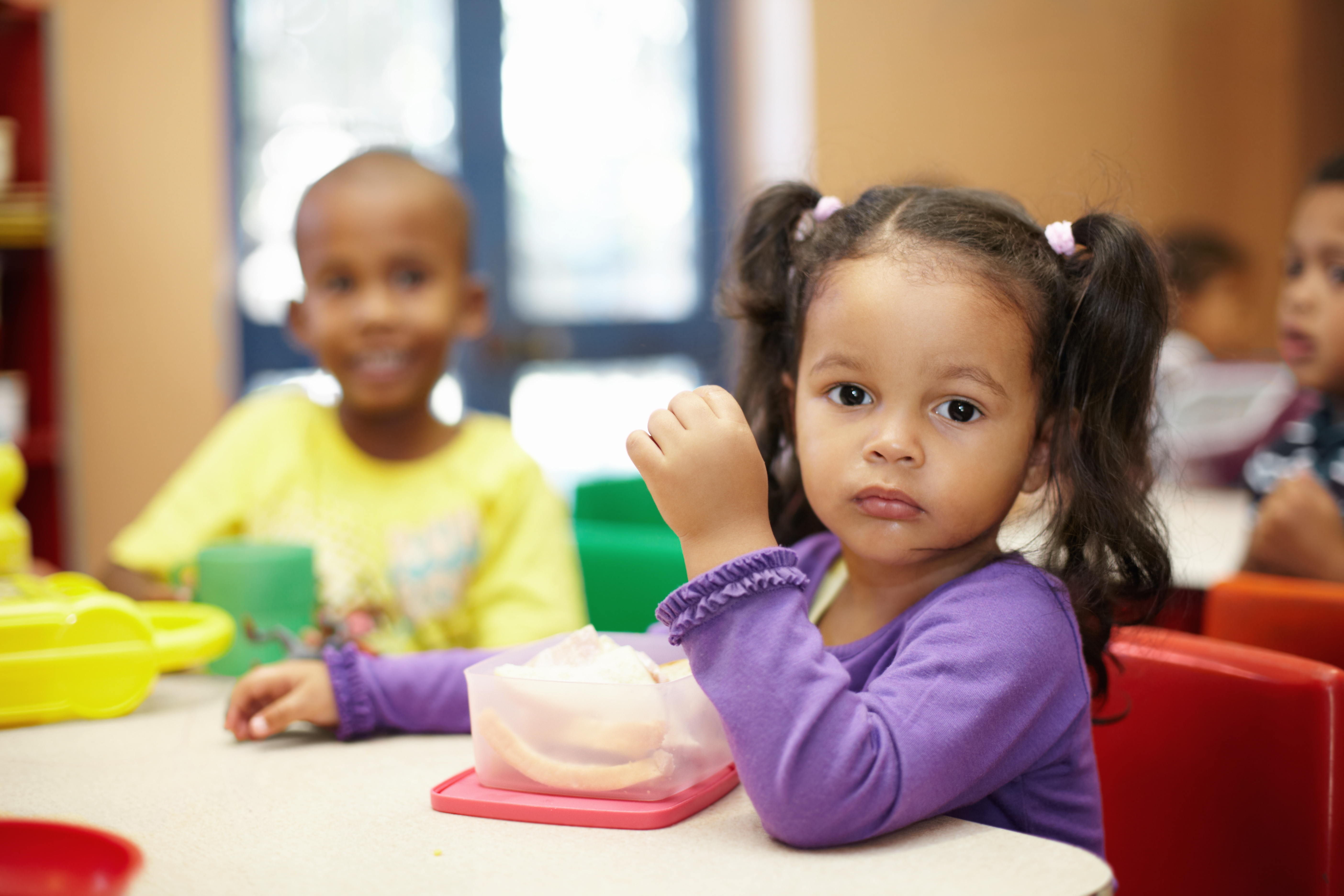 Pre-school children on their lunch break eating sandwiches